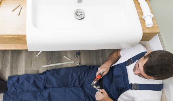 ¿A qué altura colocar el desagüe para el lavabo según la norma de agua y saneamiento?